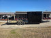 8.5' X 24' Hybrid Trailer Black With Black Out Package 7K Axles left side angled view picture with ramp down 