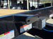 8.5x20 I Beam Deck over Dovetail Equipment Trailer 2-7k Axles with King Kong Ramps Spare tire rack view 