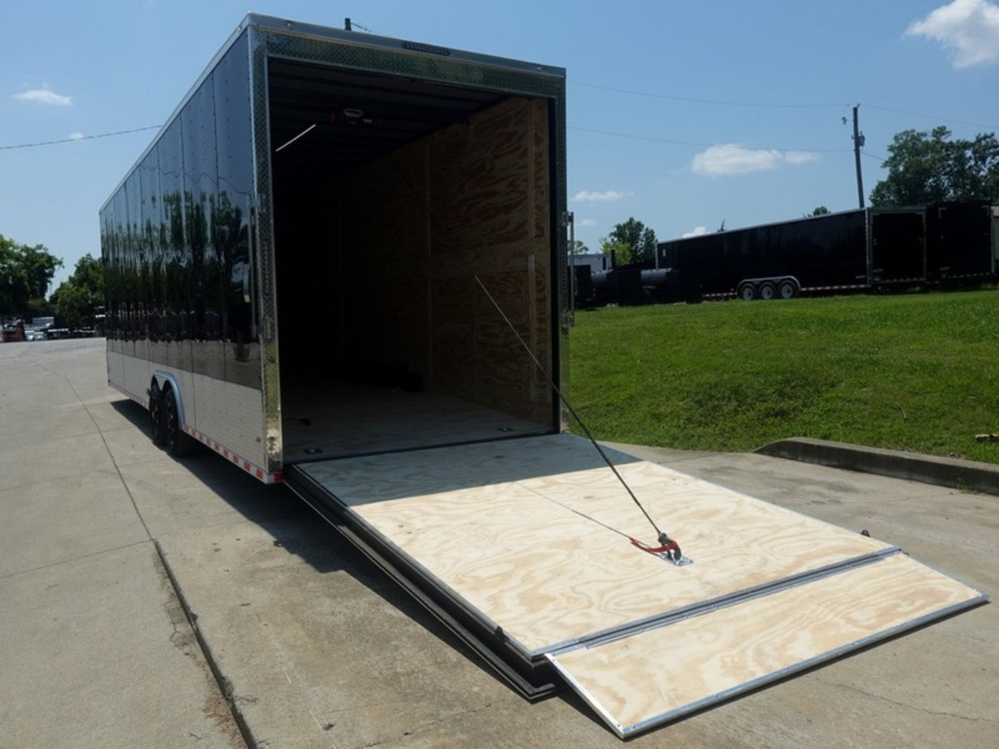 8.5x30 Black Enclosed 2-5200lb Axles 9' Interior Height with Winch Rear Ramp Lowered Left Side