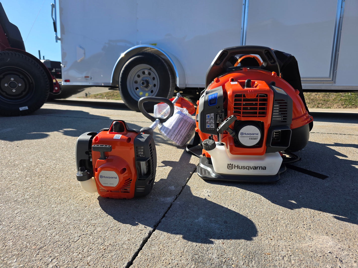 Ferris SRS Z1 36" 19HP 5901939 Kawasaki Stand-On Mower Handhelds Enclosed Trailer Bundle hand held with trailer background view picture 