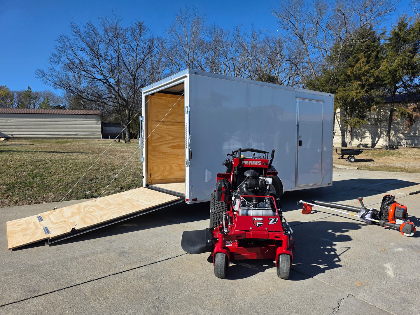 Ferris SRS Z1 36" 19HP 5901939 Kawasaki Stand-On Mower Handhelds Enclosed Trailer Bundle left angled with ramp down view picture 